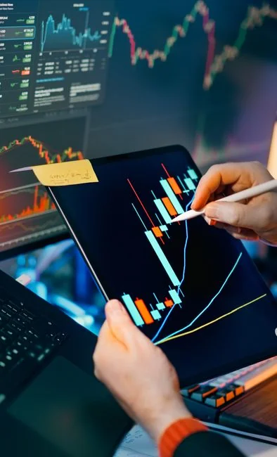 Un espace de travail moderne où des mains analysent des données marketing sur un ordinateur portable et des documents papier.